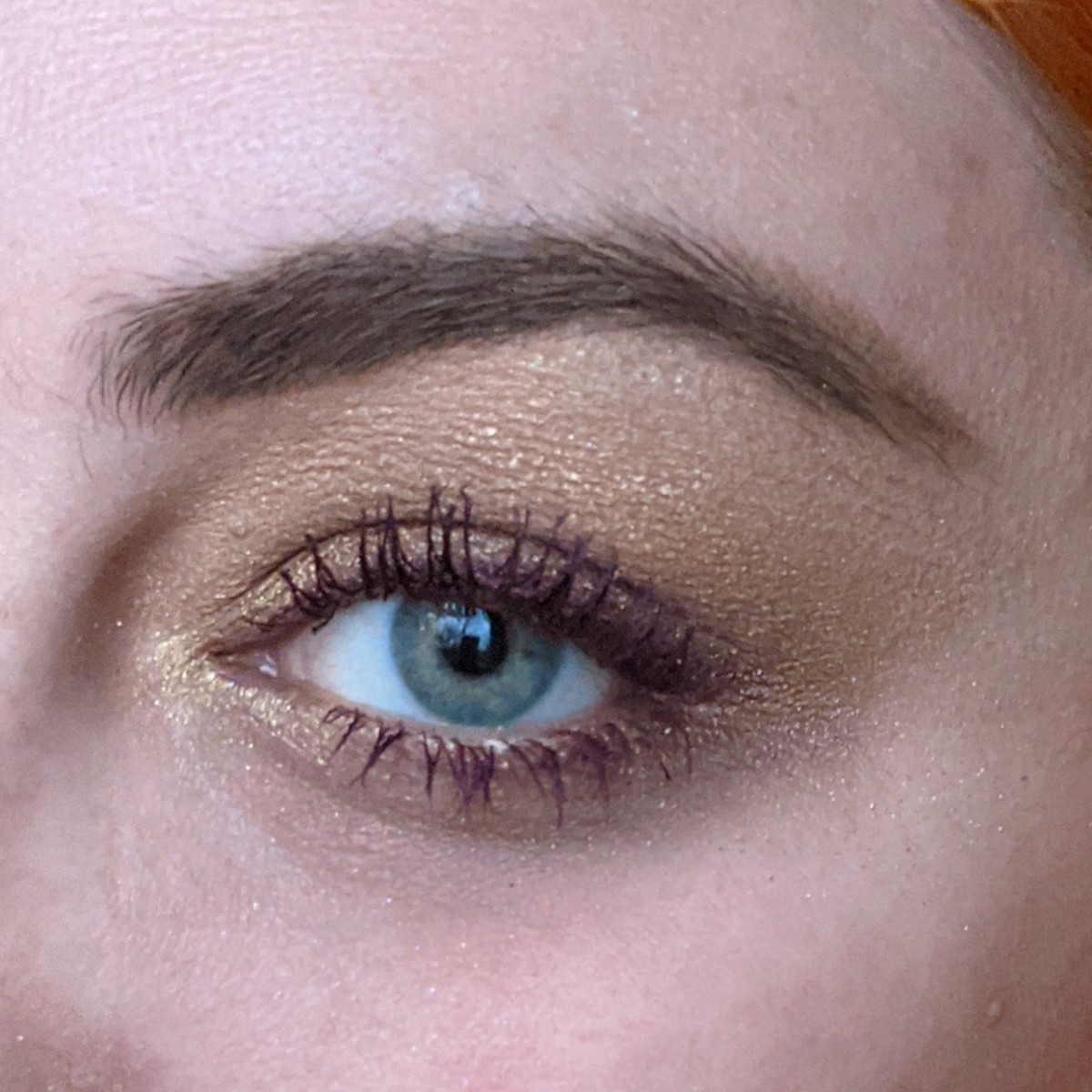 A complementary color look of gold and purple on my eye, using the Urban Decan Naked Honey Palette with L’Oreal Volumizing Mascara in Deep Purple. 